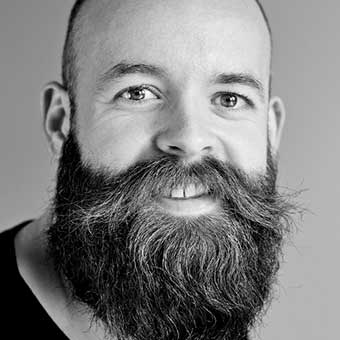 A black and white photo of a bearded man.
