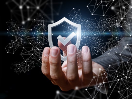 A mechanic's hand proudly displaying a check-marked shield.