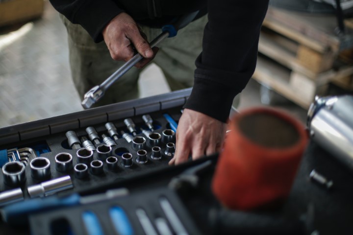 A diesel mechanics is working on a wrench in a workshop.